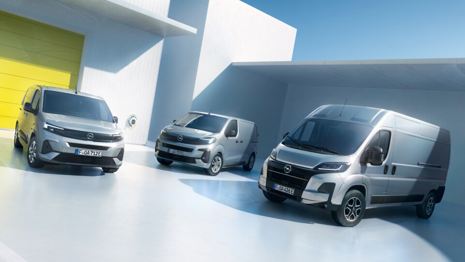 Opel Nutzfahrzeuge in silber nebeneinander vor einer Lagerhalle. Combo, Vivaro, Movano.