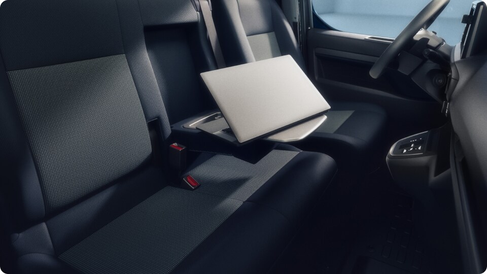 Der Innenraum des Vivaro mit einem Laptop, der auf einem ausklappbaren Sitztisch liegt